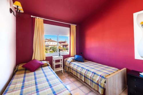 邦蒙特特雷斯诺维斯Fabuloso ROMANI entre mar y montañas的宿舍间的两张床,设有红色的墙壁和窗户。
