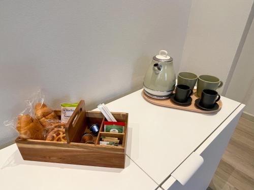 恩波利7Suites的柜台上的一盒糕点和咖啡杯