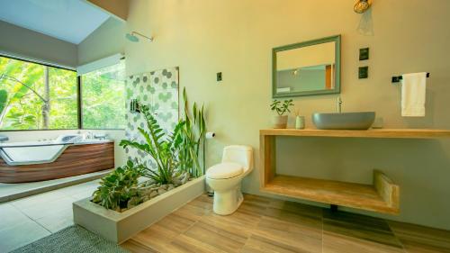 福尔图纳Eden Organic Farm & Bungalows的浴室配有盥洗盆、卫生间和浴缸。