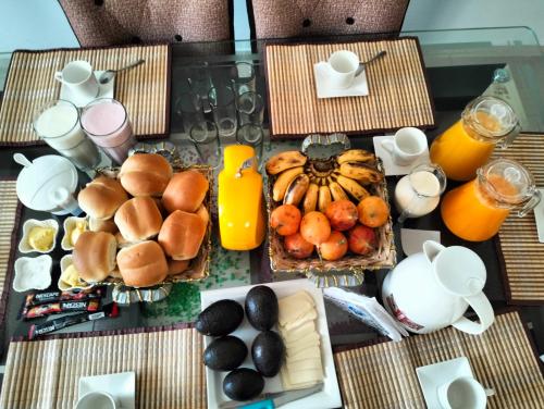 纳斯卡Alemar's House的餐桌上摆放着早餐食品和橙汁