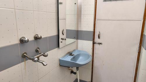 科塔Hotel Vandana的浴室设有蓝色水槽和镜子