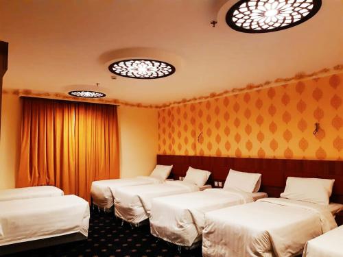 麦加فندق انوار المشاعرالفندقية的灯火通明的房间的一排床位