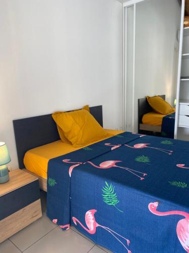 萨莱比梅Villa marigua 2的一间卧室配有一张带蓝色毯子和粉红色调的床