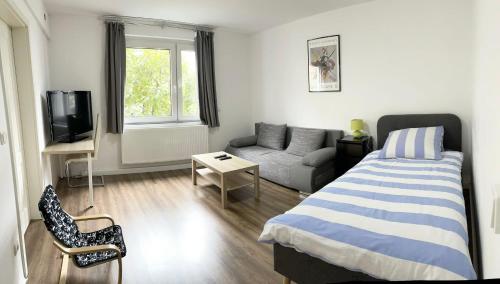 杜伊斯堡Easy to Düsseldorf Messe, 2-bedroom Apartment with kitchen and garden的一间带床和沙发的小卧室