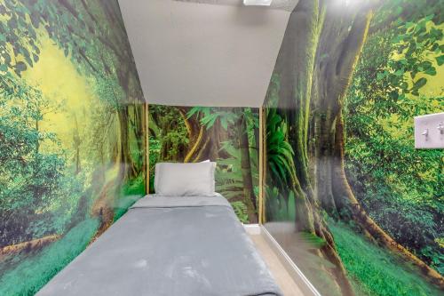 鸽子谷Bare Assets的卧室的墙上装饰有丛林壁画