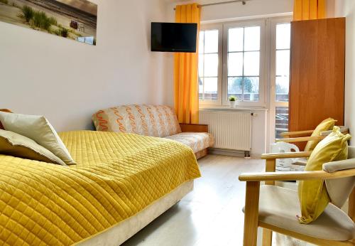 弗瓦迪斯瓦沃沃Dom Wczasowy Chlapovia的一间卧室配有黄色的床和沙发