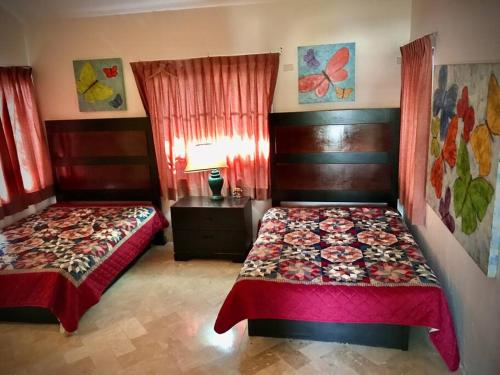 Casa Cyca, casa de campo, hasta 50 en cama c/clima的一间卧室设有两张床、一张桌子和窗户。
