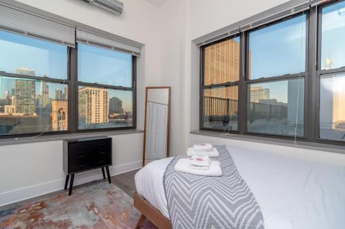 芝加哥McCormick place luxury Penthouse Duplex with personal rooftop with optional parking for 8 guests的一间卧室配有一张床,窗户享有城市天际线