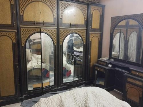 Aţ Ţarfāyahحلوان的卧室设有大型木柜和玻璃门