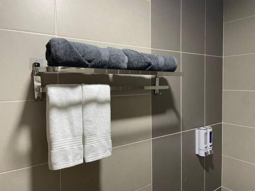 加影Affordable Family Stay in Bangi的带毛巾的浴室内的毛巾架