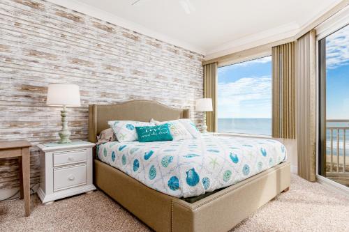 大洋城Gateway Grand的一间卧室设有一张床,享有海景
