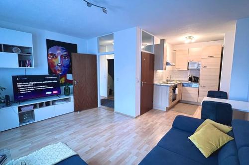 林茨Apartment 14 im Herzen von Linz的一间带蓝色沙发的客厅和一间厨房