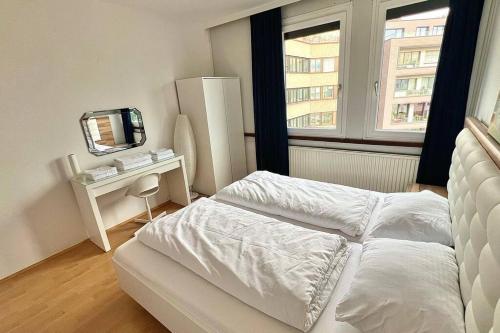 林茨Apartment 14 im Herzen von Linz的白色卧室配有床和镜子