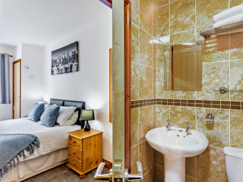 Chew Magna2 bed property in Bath 37147的一间卧室配有一张床、一个水槽和淋浴
