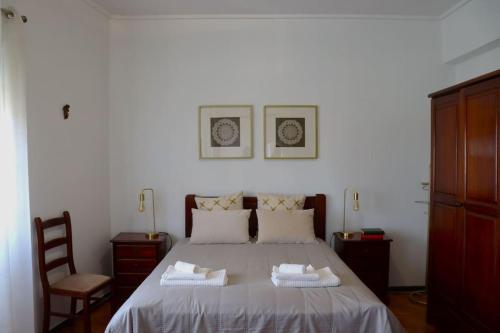 阿马多拉Judith House - Amadora Este的一间卧室配有一张床,上面有两条毛巾