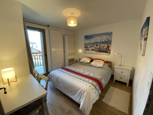 普拉波特尔les 7 laux immobilier chalet E的一间卧室配有一张床、一张书桌和一个窗户。