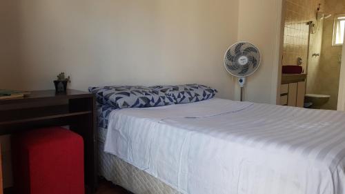 圣保罗Suíte em São Paulo的一间卧室配有一张床和一张带风扇的书桌