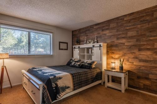 马姆莫斯湖Cozy Cabin-Style Condo in Central Location的一间卧室设有一张床和木墙