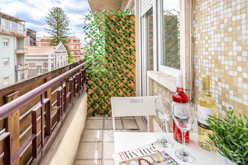 阿马多拉Santos Mattos Guesthouse & Apartments by Lisbon with Sintra的阳台配有桌子和两杯葡萄酒