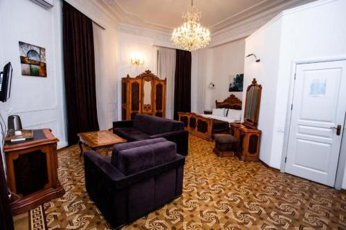 巴库Malakan Boutique Nizami Hotel的带沙发和椅子的客厅以及卧室