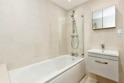 Brand new modern Cheltenham home的白色的浴室设有浴缸和水槽。