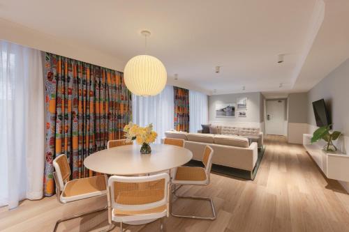 悉尼齐本德尔阿迪娜公寓酒店的客厅配有桌椅和沙发