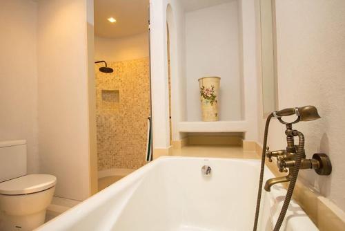 考陶The Chelona的带白色浴缸的浴室和卫生间