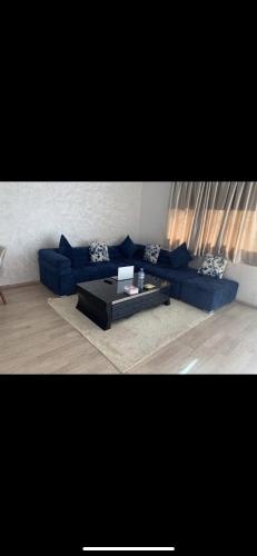 卡萨布兰卡Jolie appartement avec terrasse的客厅配有蓝色的沙发和茶几