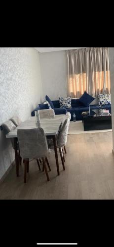 卡萨布兰卡Jolie appartement avec terrasse的客厅配有桌椅和沙发