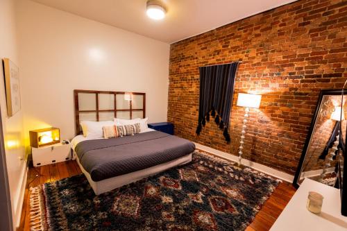 斯普林菲尔德The Boho Loft的一间卧室设有一张床和砖墙