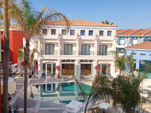罗希姆诺Grecotel Plaza Beach House的一座别墅,设有游泳池和棕榈树
