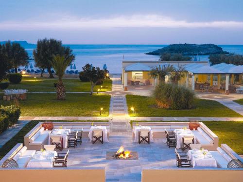 锡西格雷科泰尔梅利皇宫酒店的一个带桌椅的户外用餐区,享有海景。