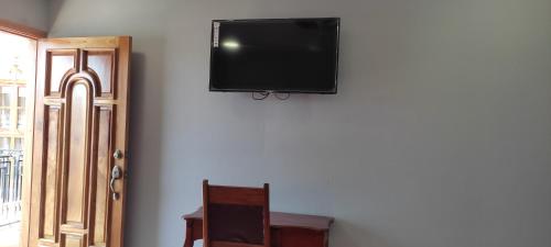 里瓦斯HOSTAL RIVAS INNS的挂在墙上的平面电视
