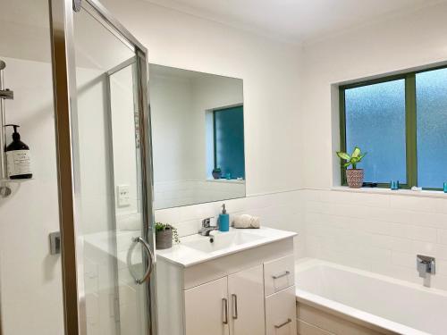 帕帕莫阿Sanddune Delight的白色的浴室设有水槽和淋浴。