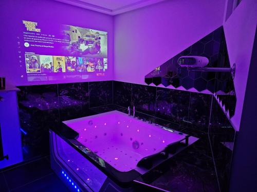 迪弗当日Magnifique Suite Spa Luxembourg的紫色浴室设有紫色照明的浴缸