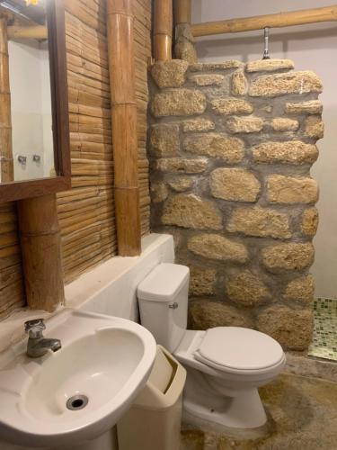 维加伊托La Cabaña del Mar Vichayito的浴室配有盥洗池、卫生间和石墙。