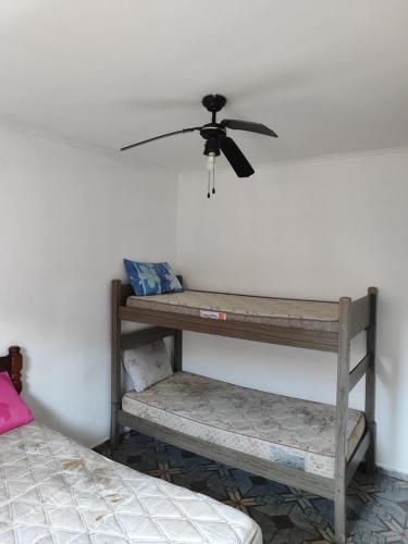 蒙加瓜Casa de praia em Mongaguá的一间带吊扇和两个架子的房间