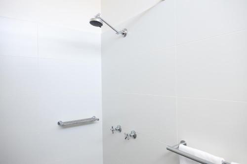 格拉德斯通The Club Hotel的浴室设有白色墙壁和镀铬装置