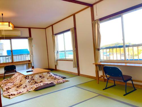 Kanayamaおんせん民宿望海的客房设有桌椅和窗户。
