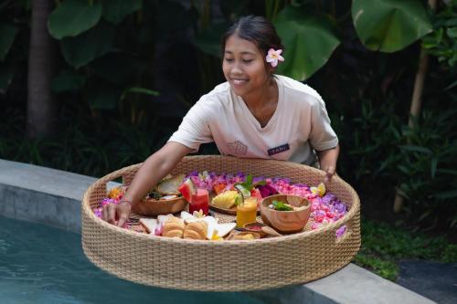 乌布Sanctuary Villas的坐在一篮子食物旁的女人