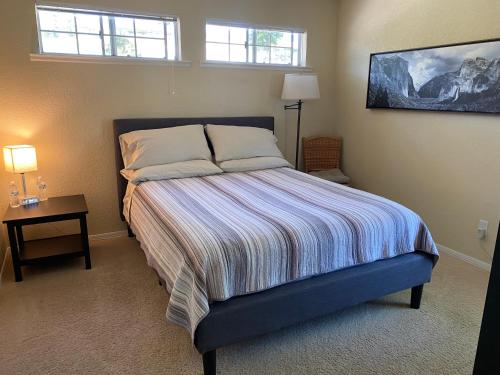 科斯戈尔德Oak Retreat by Yosemite National Park的一间卧室配有一张床、一张桌子和两个窗户