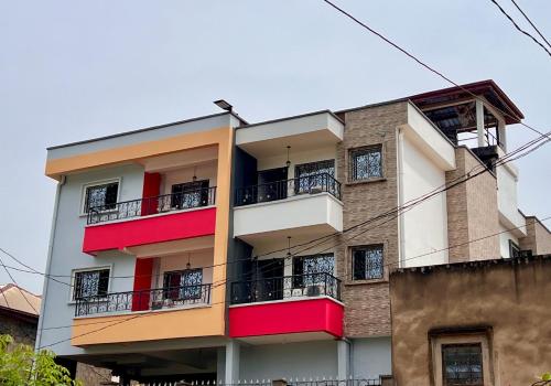 雅温得Residence Ethan Nji - Tropical Paradise的公寓大楼设有红色和白色的阳台