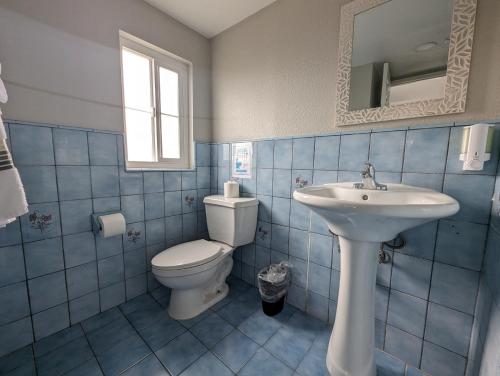 洛杉矶海洋公园旅馆的蓝色瓷砖浴室设有卫生间和水槽
