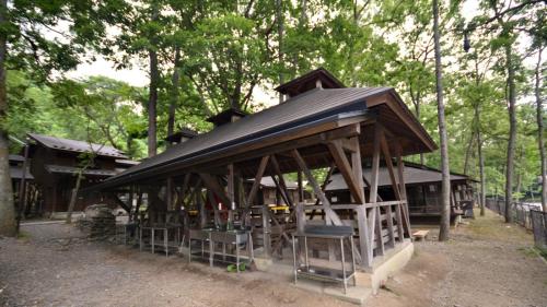 YumotoTabino Camping Base Akiu Tree House - Vacation STAY 23971v的林中带黑色屋顶的凉亭