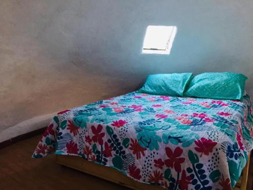 HorconDomo Sol Del Valle的一间卧室配有一张带五颜六色棉被的床