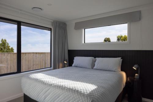 北哈夫洛克The Corner on Te Mata的一间卧室设有一张床和两个窗户。