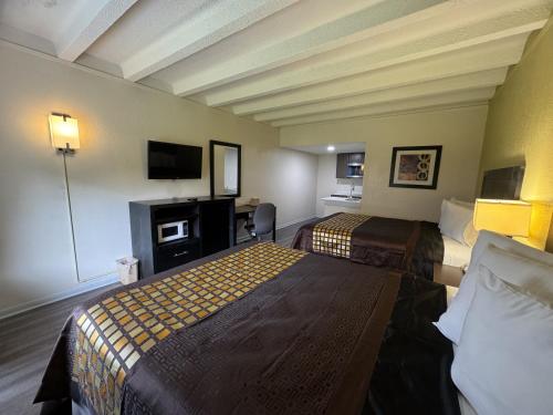 纽波特纽斯James River Inn & Suites的酒店客房配有两张床和一张书桌