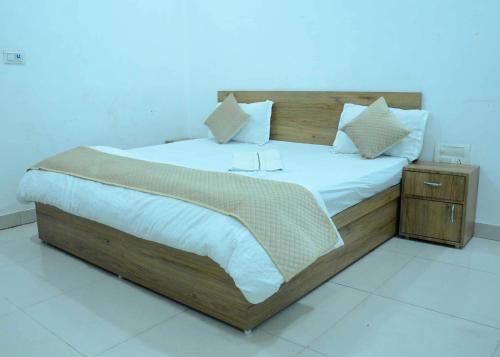 JīndOYO HOTEL GREEN的一间卧室配有一张大木床和白色床单