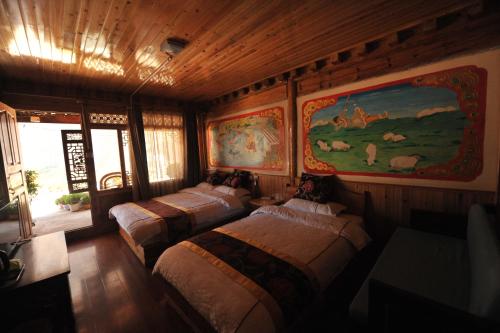 香格里拉虎跳峡卓玛客栈的一间设有三张床的客房,墙上挂着一幅画