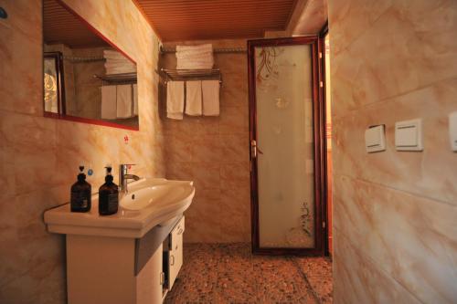 香格里拉虎跳峡卓玛客栈的一间带水槽、镜子和淋浴的浴室